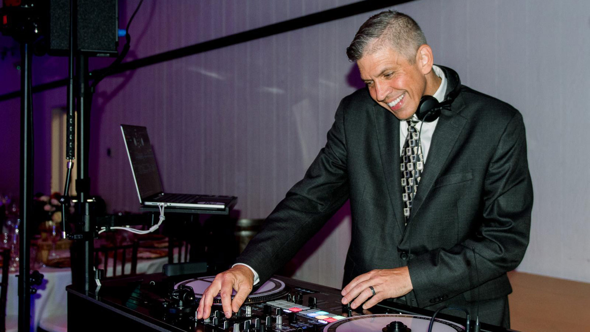 Sir Force DJ performing at a wedding reception with professional lighting and a packed dance floor