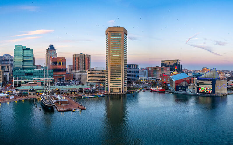 Baltimore Inner Harbor skyline at sunset with colorful reflections on the water