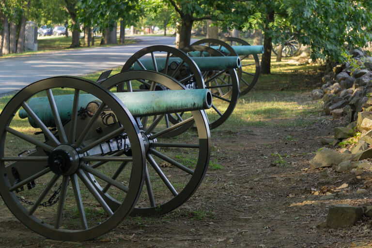Historic Civil War cannons along a stone wall at Gettysburg National Military Park