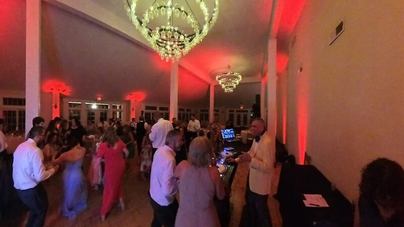 Wedding guest making a song request at the DJ booth during the reception