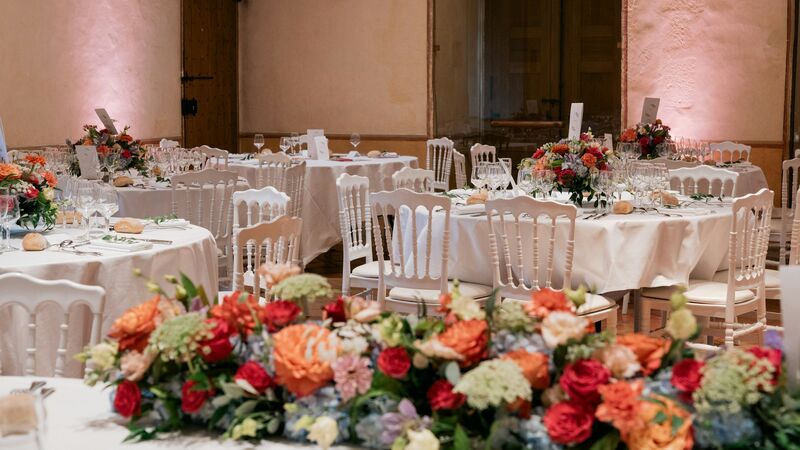 Elegant empty wedding venue with tables set for a reception and warm ambient lighting