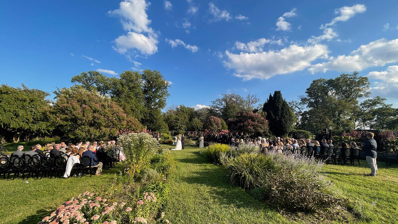 Outdoor wedding ceremony at Baltimore conservatory with guests seated in garden setting