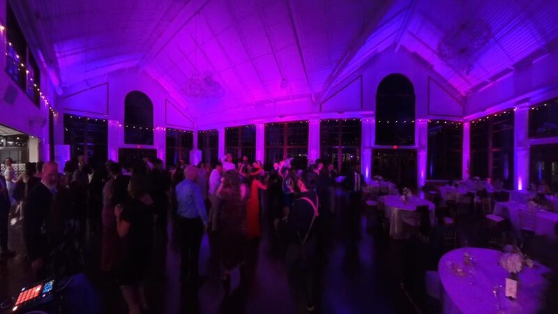 Wedding reception with bold raspberry and purple uplighting washing the walls