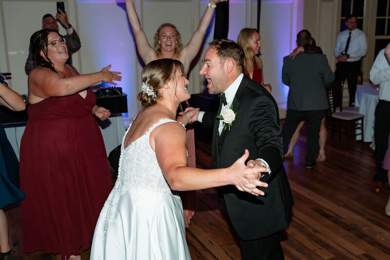 Bride and groom dancing on a packed wedding dance floor