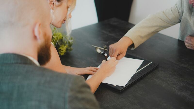 Engaged couple reviewing a wedding booking proposal on a laptop