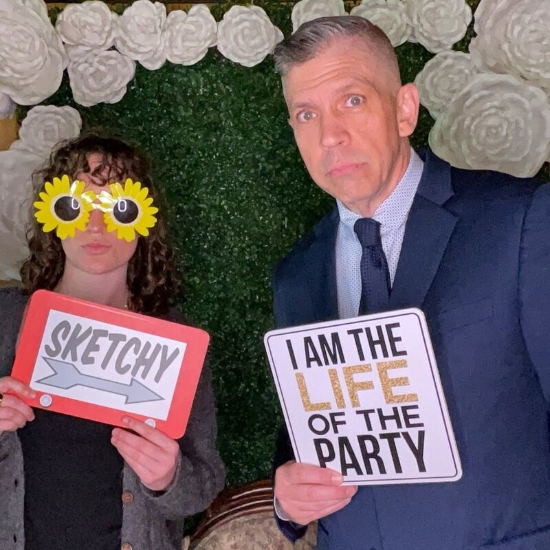 Photo booth fun with life of the party sign