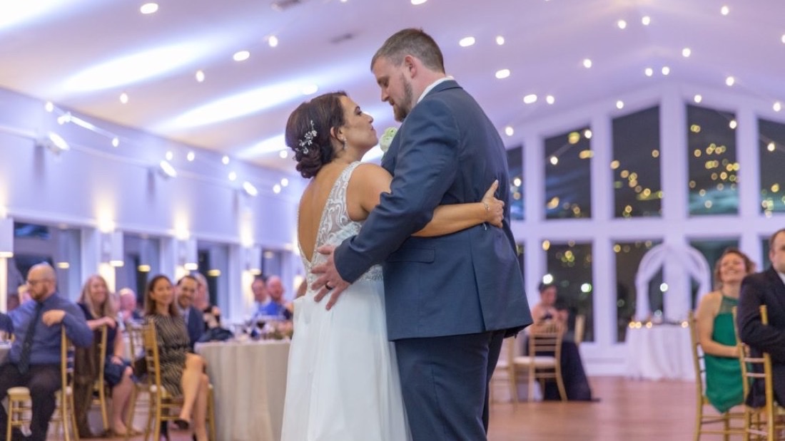 First dance in the Anchor Inn ballroom with string lights and guests seated around tables