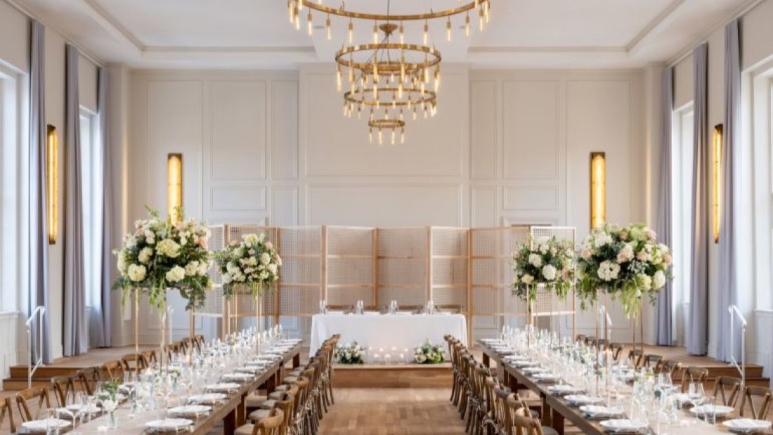 Elegant ballroom at The Visitation Hotel set for a wedding reception with chandelier and floral arrangements